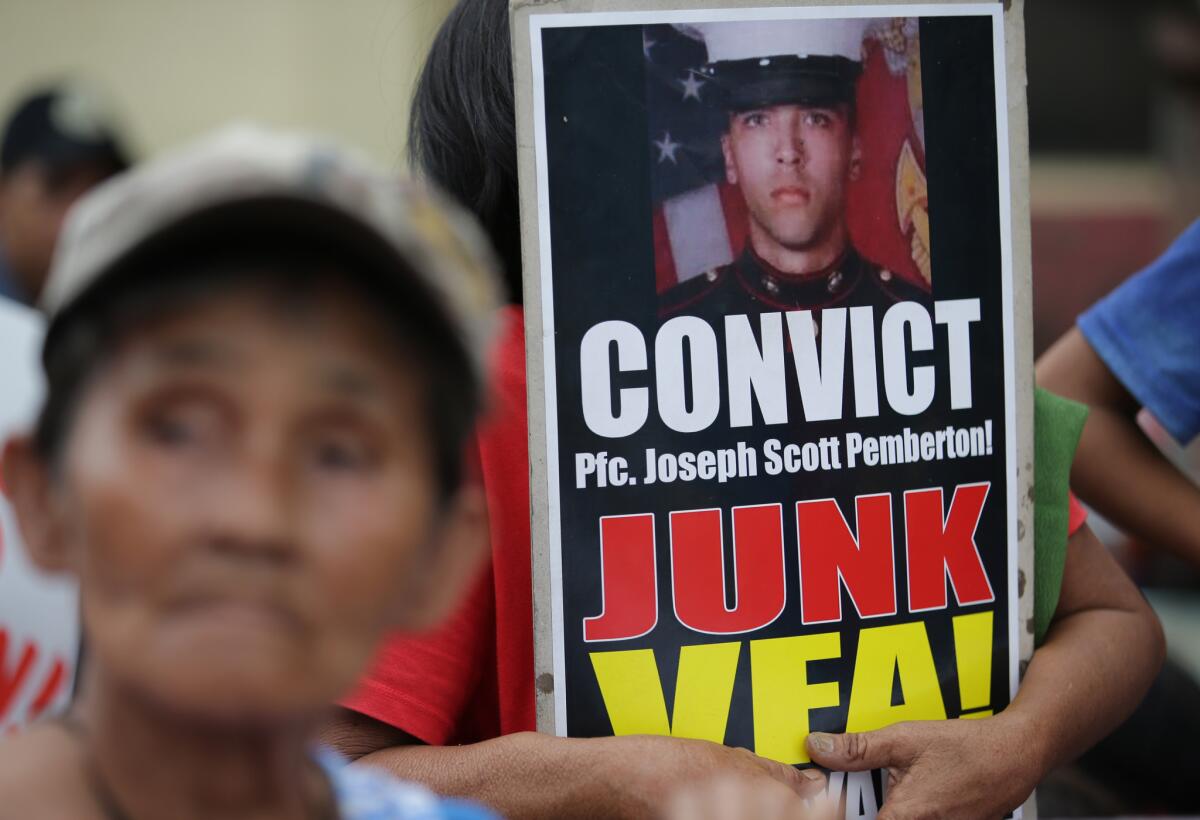 A protester beside a poster with a picture of U.S. Marine Lance Cpl. Joseph Scott Pemberton outside court Tuesday at Olongapo, Philippines.