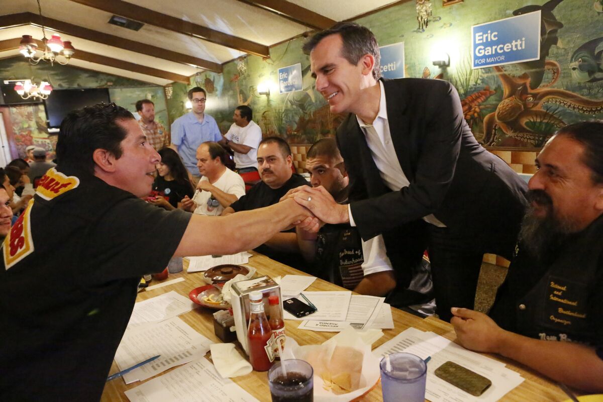Eric Garcetti shakes hands with Donald Galaz as he meets with dock workers and other backers at a Wilmington restaurant in May while campaigning for mayor of Los Angeles.