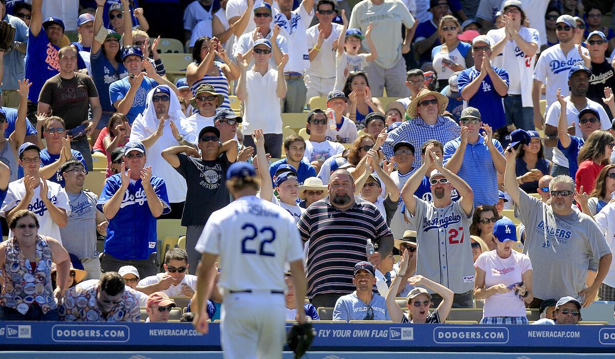 Dodger fans applaud Clayton Kershaw as he comes off the mound.