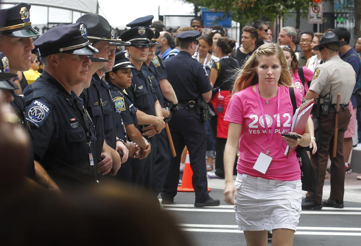 A pro-choice activist walks through a phalanx of police officers separating their group from antiabortion demonstrators in Charlotte, N.C., in September 2012.