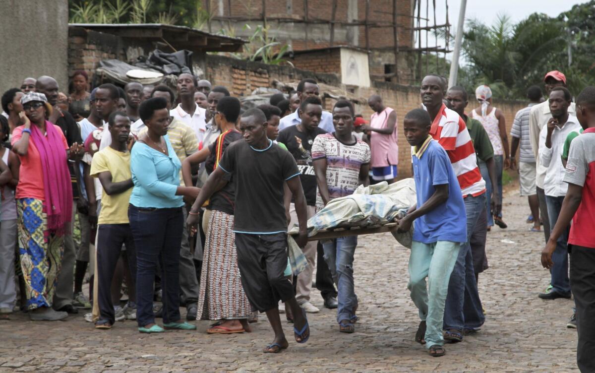 Men carry away a dead body in the Nyakabiga neighborhood of Bujumbura, Burundi, Saturday, Dec. 12, 2015. Burundi's political violence continued Saturday as a number of people were found shot dead in the Nyakabiga neighborhood of the capital.