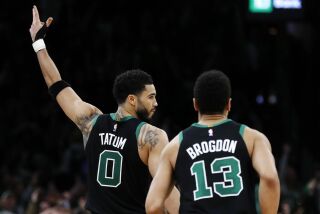 Jayson Tatum, de los Celtics de Boston, festeja junto a su compañero Malcolm Brogdon durante el partido del viernes 31 de marzo de 2023, ante el Jazz de Utah (AP Foto/Michael Dwyer)