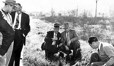 A 1947 photo shows reporter Will Fowler, far left, with LAPD's Ray Pinker, Dets. Harry Hansen and Finis Brown, and a lab technician at the Norton Avenue lot where the body of "Black Dahlia" Elizabeth Short was found.