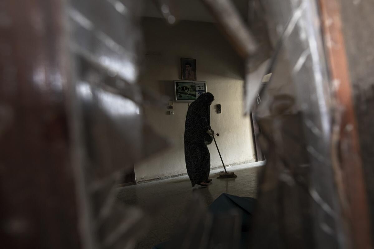 Silhouette of woman cleaning her damaged home