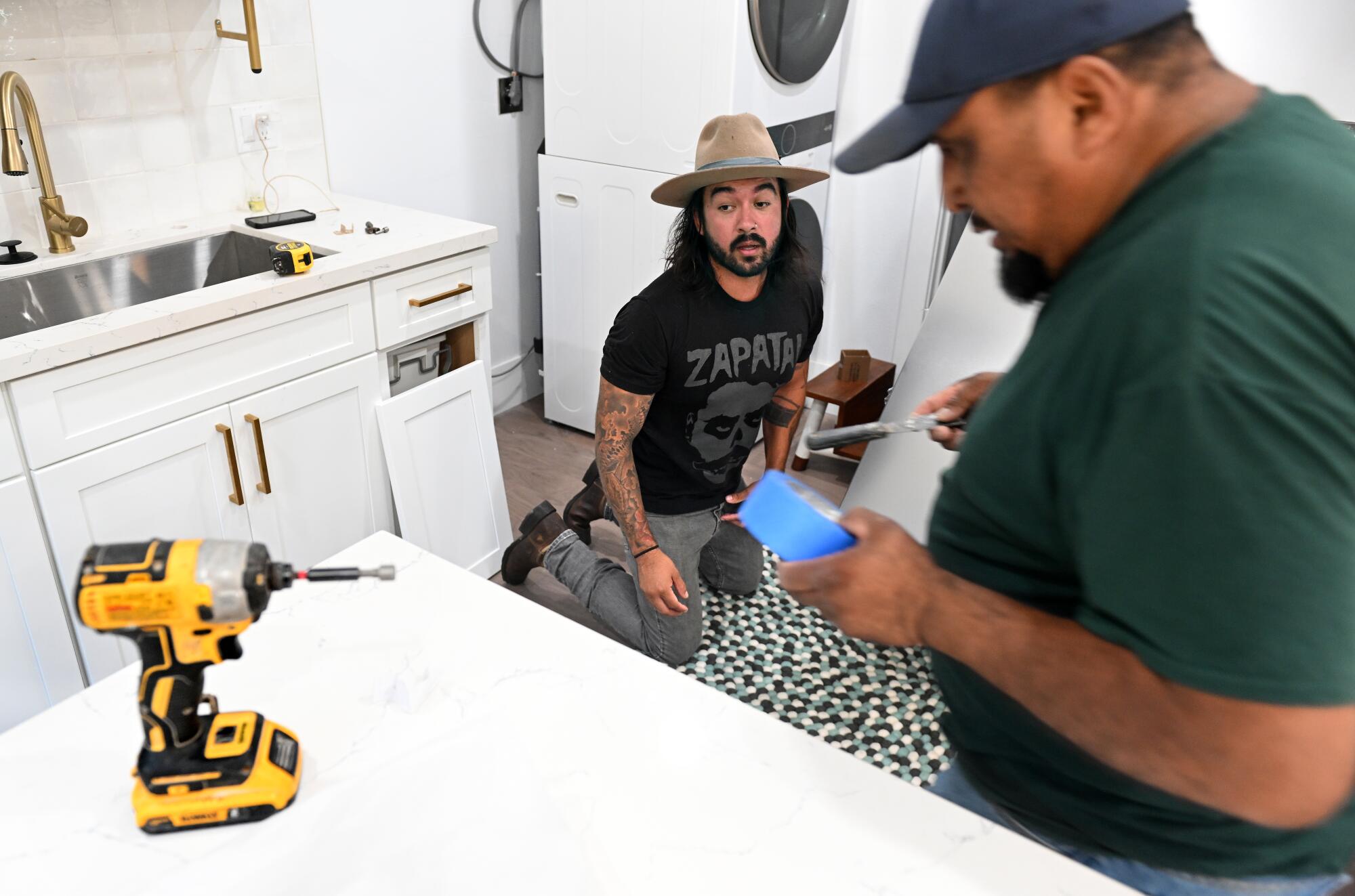 Julio Arana works on one of his rental properties in Santa Ana.