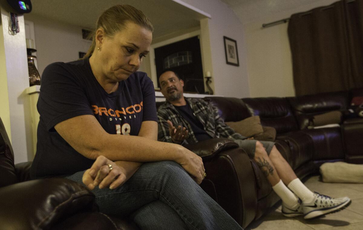 SAN BERNARDINO, CALIF. -- SUNDAY, DECEMBER 6, 2015: Trish Hughes, left, a Democrat, and husband Robert Garcia, right, a Republican, watched President Obama's speech from the Oval Office together at their home in San Bernardino, Calif., on Dec. 6, 2015. (Brian van der Brug / Los Angeles Times)