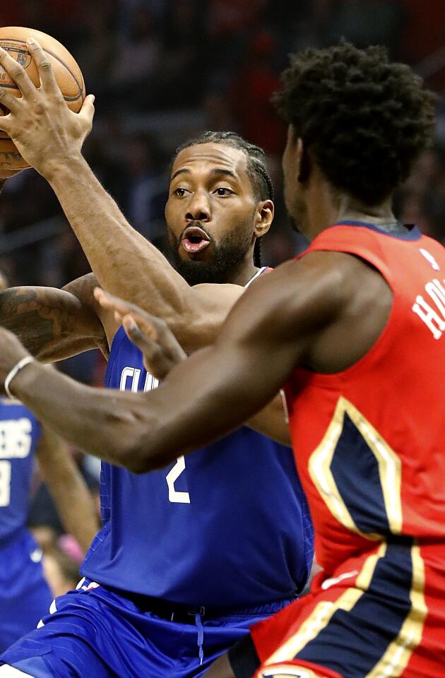 Clippers forward Kawhi Leonard drives to the basket against Pelicans guard Jrue Holiday.