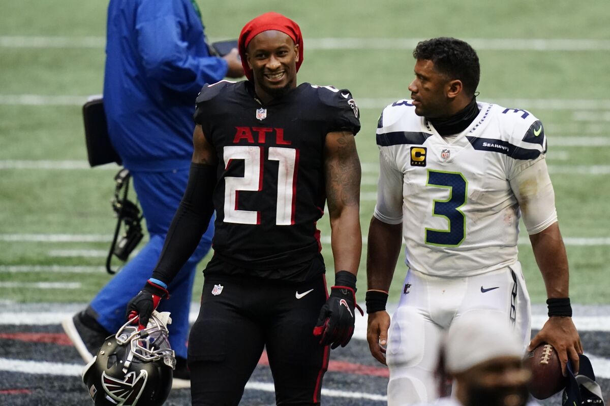 Atlanta Falcons running back Todd Gurley, left, speaks with Seattle Seahawks quarterback Russell Wilson after the second half of an NFL football game, Sunday, Sept. 13, 2020, in Atlanta. The Seattle Seahawks won 38-25. (AP Photo/Brynn Anderson)