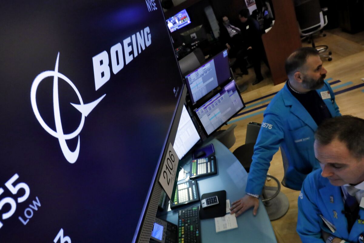 The Boeing logo appears above a trading post on the floor of the New York Stock Exchange, March 12, 2020. Boeing is reporting better numbers for airplane deliveries and orders compared with this time a year ago. Boeing said Tuesday, Feb. 8, 2022 it delivered 32 commercial jetliners in January, up from 26 in the same month last year. (AP Photo/Richard Drew, file)