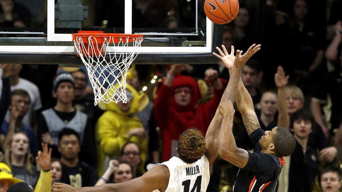 Colorado's Tory Miller (14) and Oregon State's Gary Payton, right, elevate for a rebound during the first half Wednesday night.