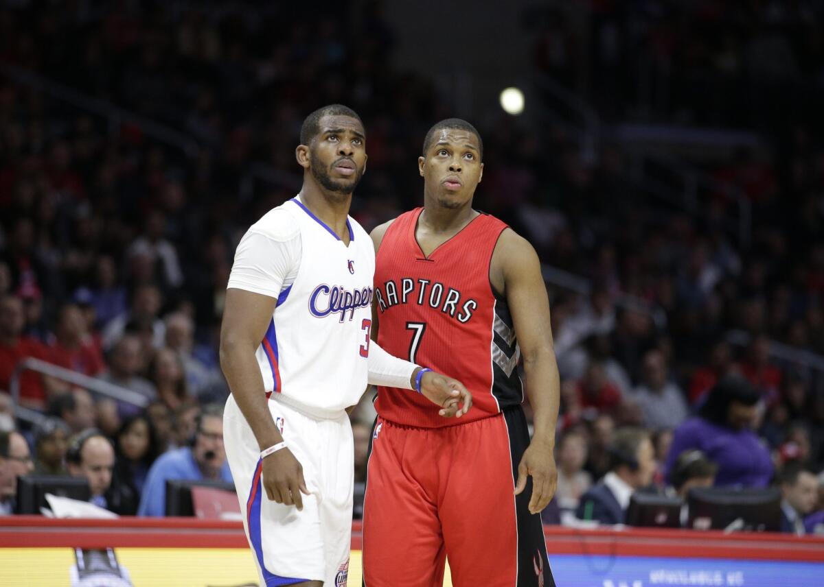 Chris Paul, left, stands next to Toronto's Kyle Lowry at Staples Center on Dec. 27.