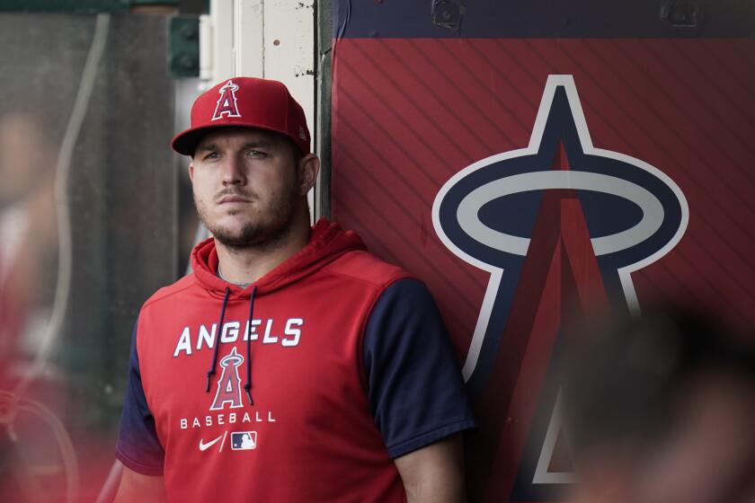 Los Angeles Angels' Mike Trout stands in the dugout before the team's baseball game against the Texas Rangers on Saturday, July 30, 2022, in Anaheim, Calif. (AP Photo/Jae C. Hong)