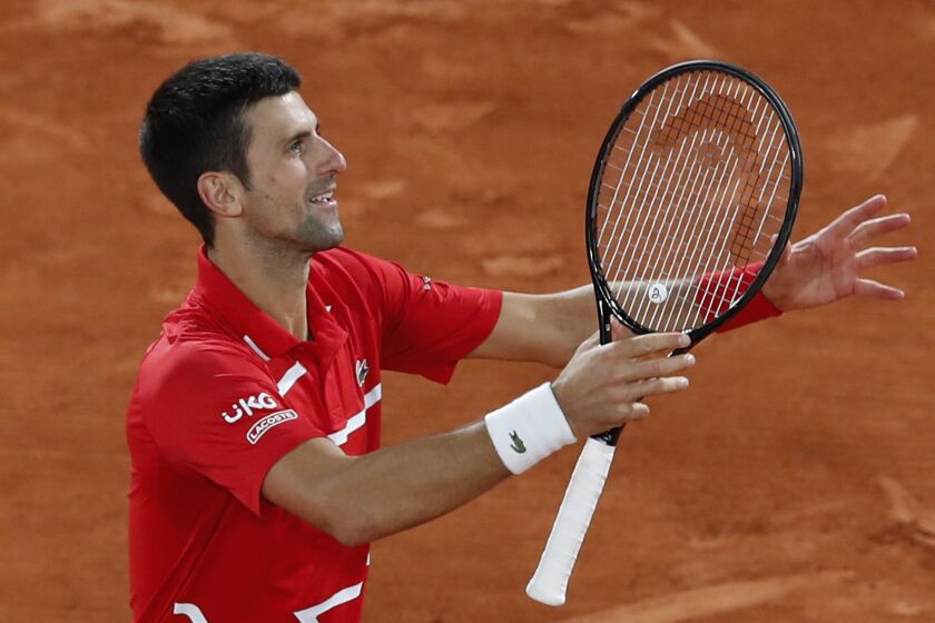 Novak Djokovic celebrates winning his French Open semifinal against Stefanos Tsitsipas on Oct. 9, 2020.