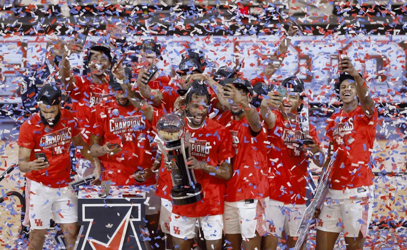 Houston guard DeJon Jarreau (3) holds the championship trophy as he stands with teammates following the team's win over Cincinnati an NCAA college basketball game in the final round of the American Athletic Conference men's tournament Sunday, March 14, 2021, in Fort Worth, Texas. (AP Photo/Ron Jenkins)