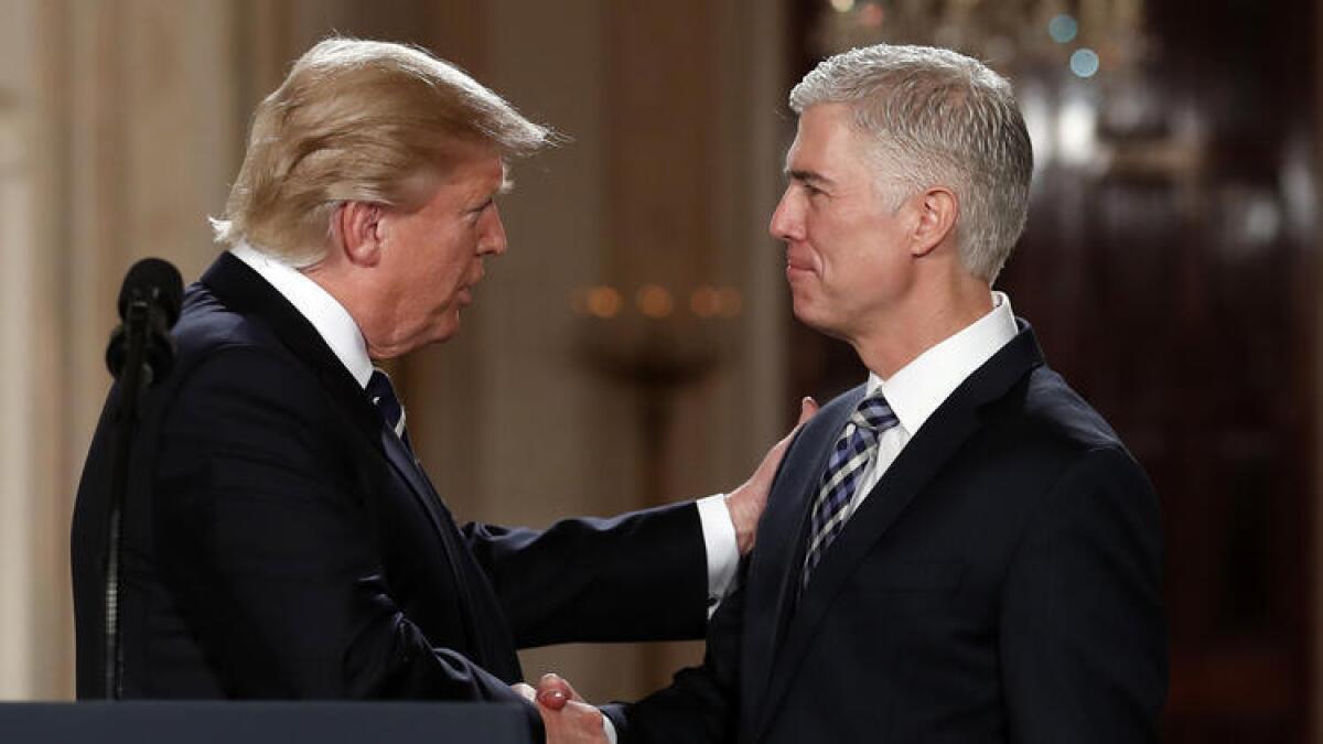 President Trump shakes the hand of his Supreme Court nominee, federal appeals court Judge Neil Gorsuch, on Tuesday night at the White House.