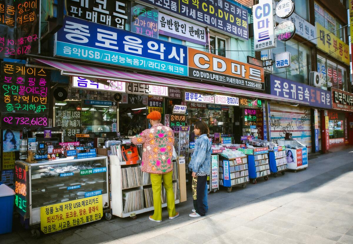 A man and a young boy look through records at an outdoor Korean music store