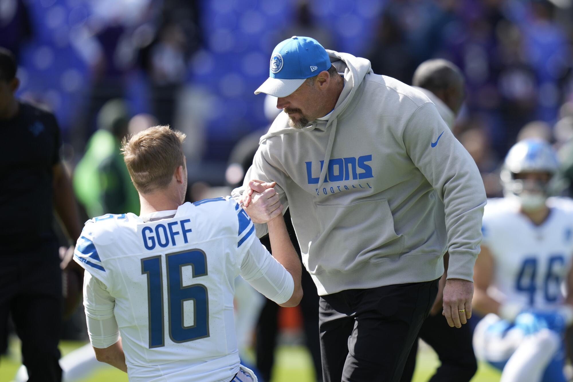 Lions coach Dan Campbell talks to quarterback Jared Goff before a game in October.