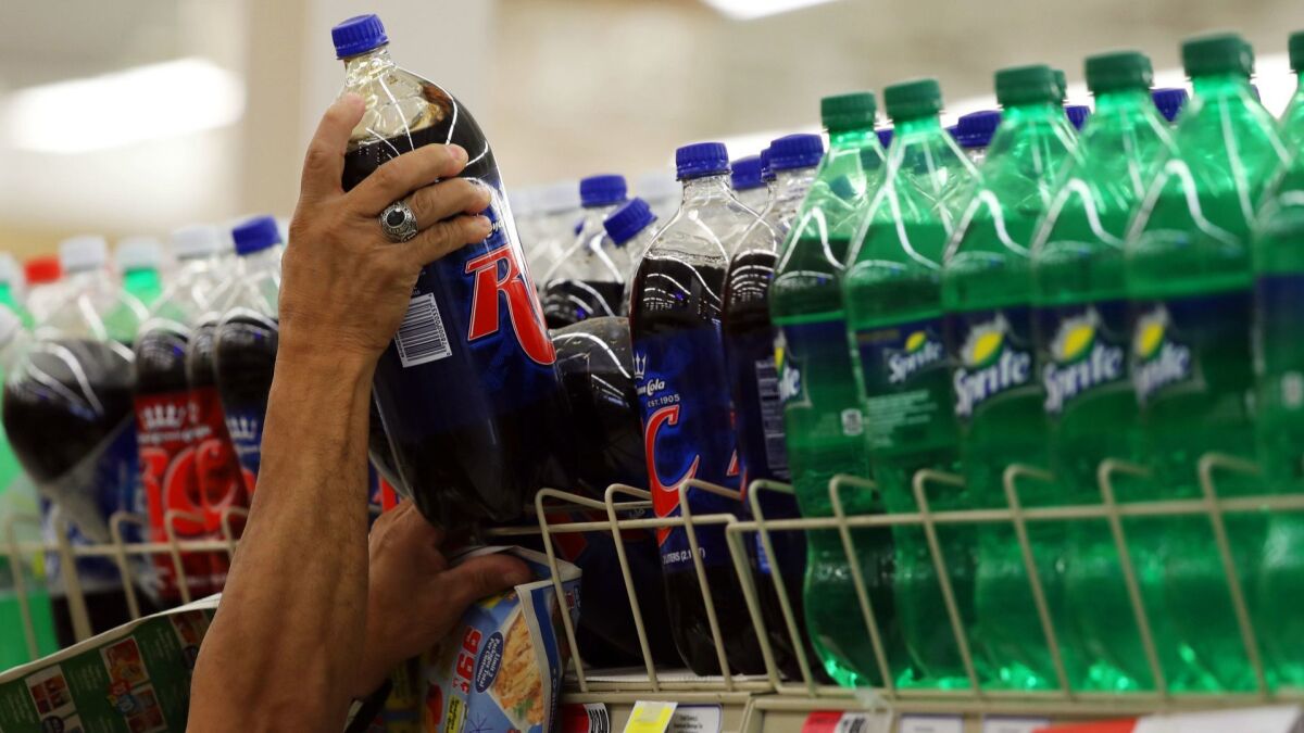 A shopper grabs a two-litre bottle of soda on Wednesday, Oct. 11, in Chicago.