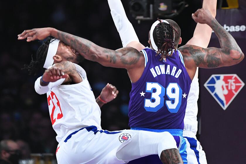 LOS ANGELES-CA-FEBRUARY 25, 2022: Los Angeles Clippers' Robert Covington, left, connects with Los Angeles Lakers' Dwight Howard at Crypto.com Arena in downtown Los Angeles on Friday, February 25, 2022. (Christina House / Los Angeles Times)