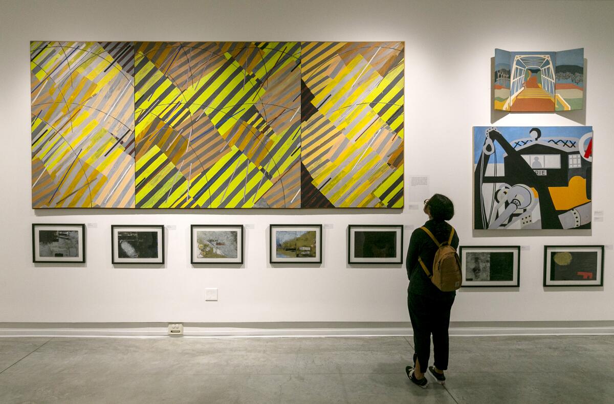 A student looks at art on a wall at the Frank M. Doyle Arts Pavilion at Orange Coast College