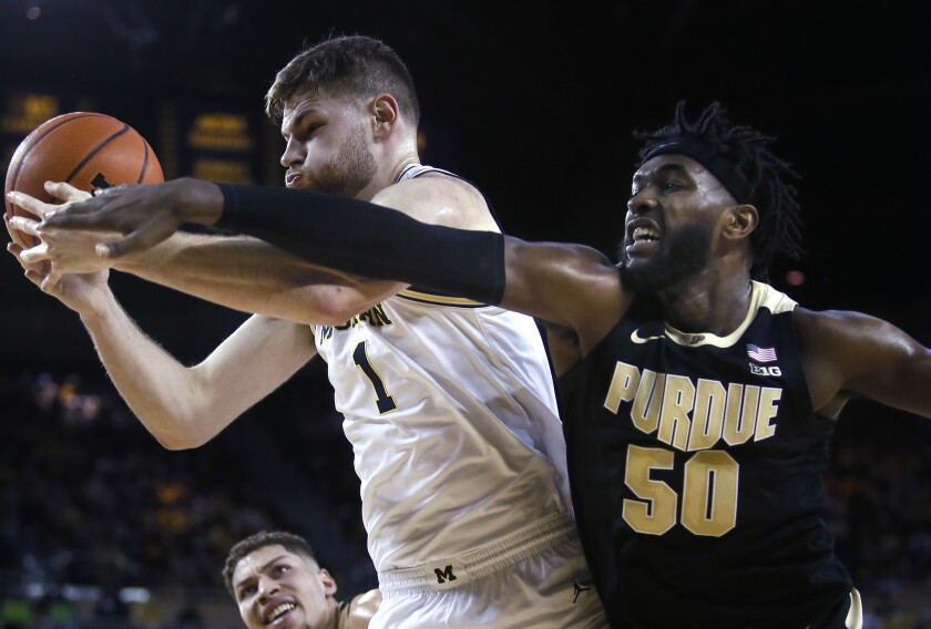 Michigan center Hunter Dickinson (1) beats Purdue forward Trevion Williams (50) to a rebound during the first half of an NCAA college basketball game Thursday, Feb. 10, 2022, in Ann Arbor, Mich. (AP Photo/Duane Burleson)