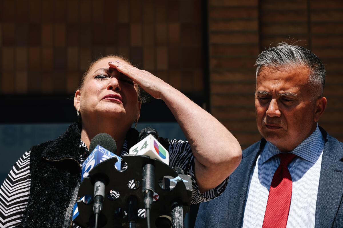 Maricela Avila, left, becomes emotional during a news conference. A retired police detective, right, looks on.