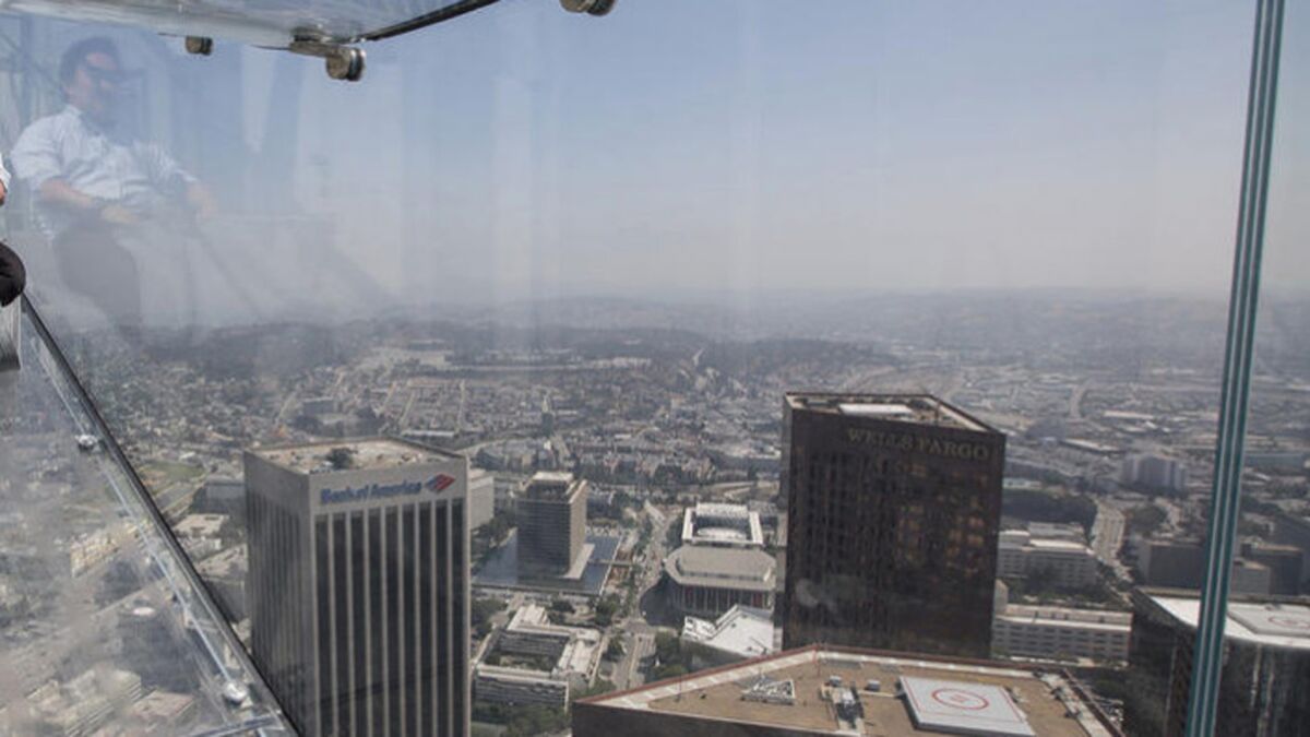 A member of the media takes a four-second ride on the Skyslide, 1,000 feet above downtown Los Angeles at the U.S. Bank Tower.