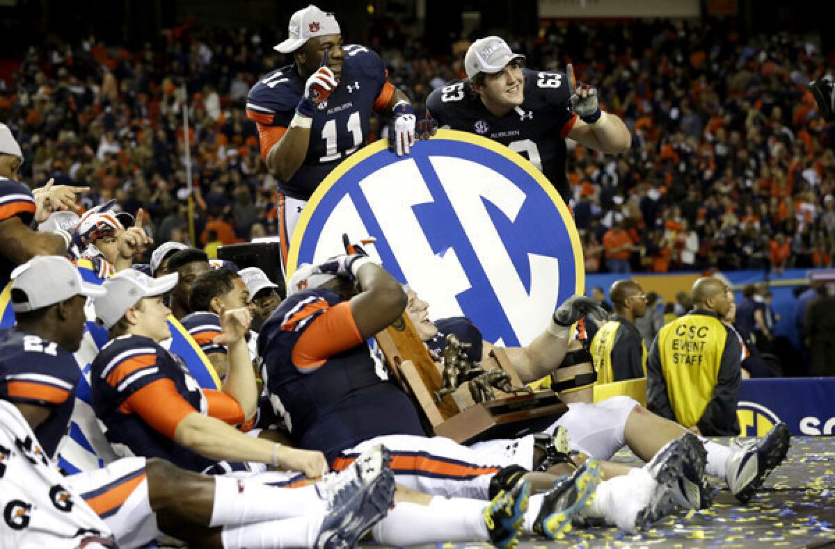 Auburn players pose with a Southeastern Conference sign after defeating Missouri in the SEC title game on Saturday.