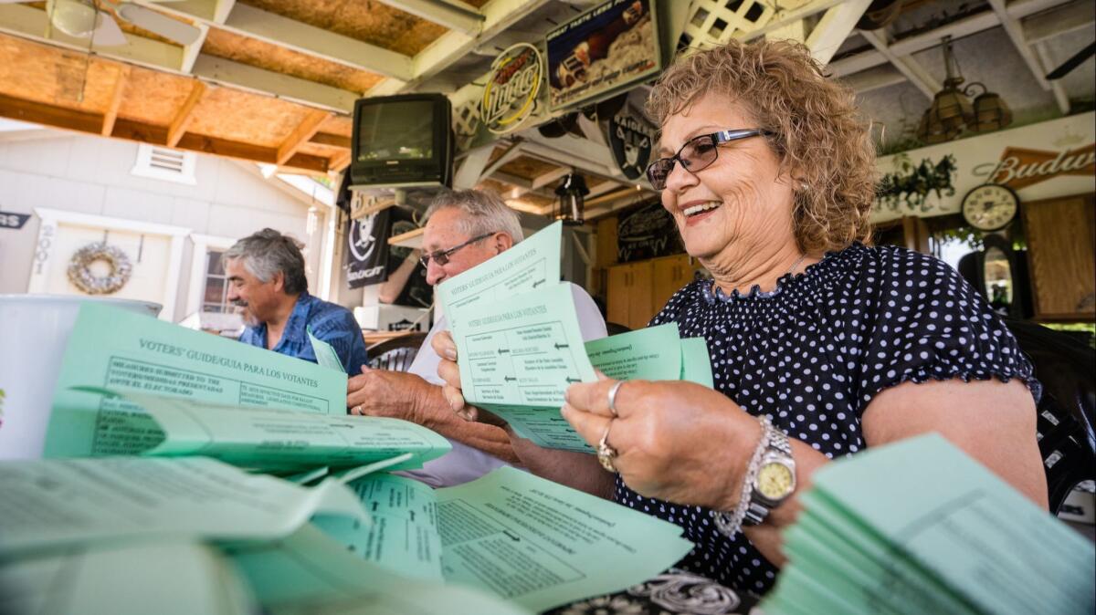Mary Gonzales-Gomez, Raul Gomez, and Jose Ojeda and other members of the Latino Community Roundtable fold Democratic voter guides for passing out to homes in Corcoran, Calif. on May 20.