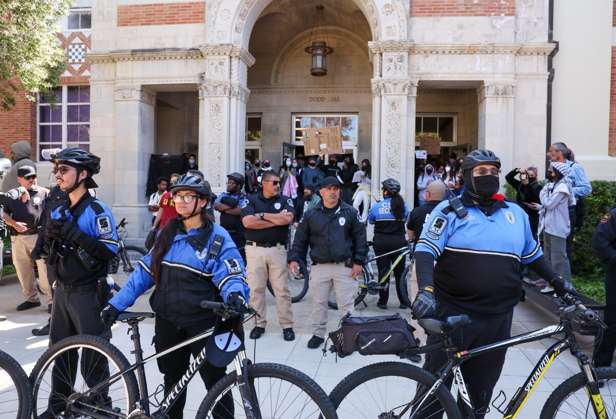 Security guards form a wall with bicycles as pro-Palestinian protesters demonstrate outside UCLA's Dodd Hall