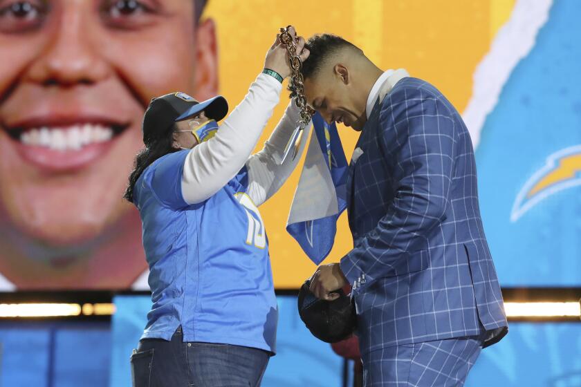 A Los Angeles Chargers fan puts a lightning bolt necklace around the neck of Northwestern tackle Rashawn Slater after the San Diego Chargers selected him with the 13th pick in the NFL football draft Thursday April 29, 2021, in Clevelandof the NFL football draft Thursday April 29, 2021, in Cleveland. (AP Photo/Gregory Payan)
