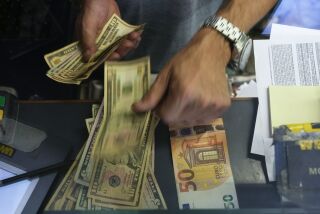 Un cajero cambia un billete de 50 euros por dólares estadounidenses en una casa de cambio, el miércoles 13 de julio de 2022, en Roma. (AP Foto/Gregorio Borgia, Archivo)