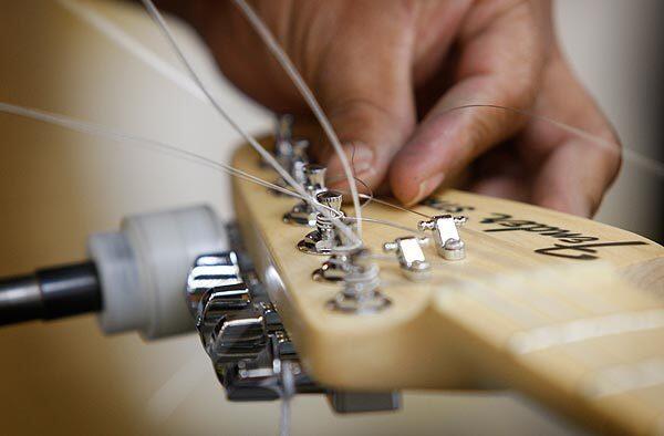 Raymunda Millan attaches steel strings to a Stratocaster at the Fender manufacturing plant in Corona. The company's electric guitars have a worldwide following.
