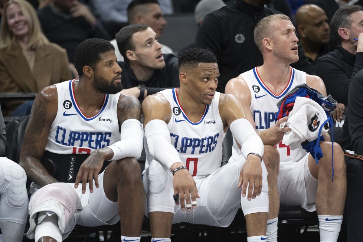 From left, the Clippers' Paul George, Russell Westbrook and Mason Plumlee watch from the bench March 3, 2023.