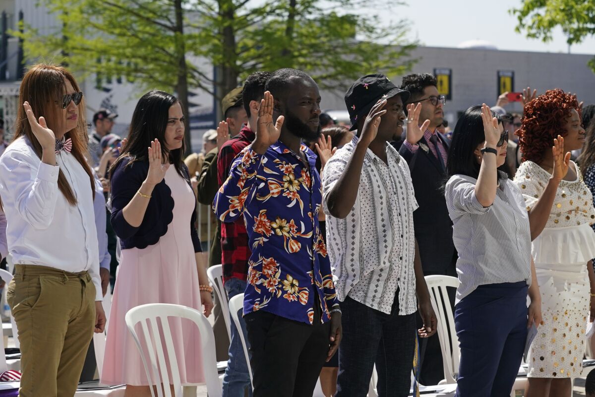 New citizens take the oath during an outdoor ceremony