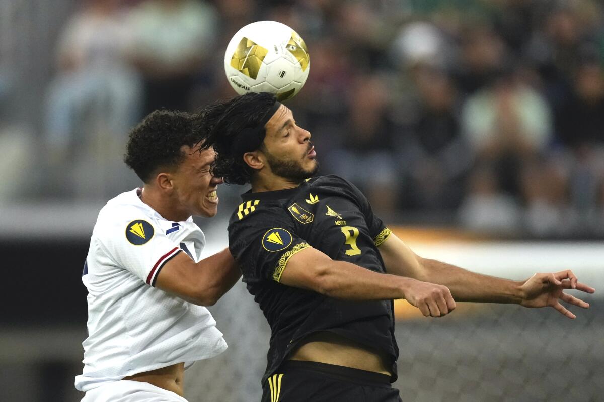 Dominican Republic midfielder Jean López, left, Mexico forward Raúl Jiménez battle for the ball.