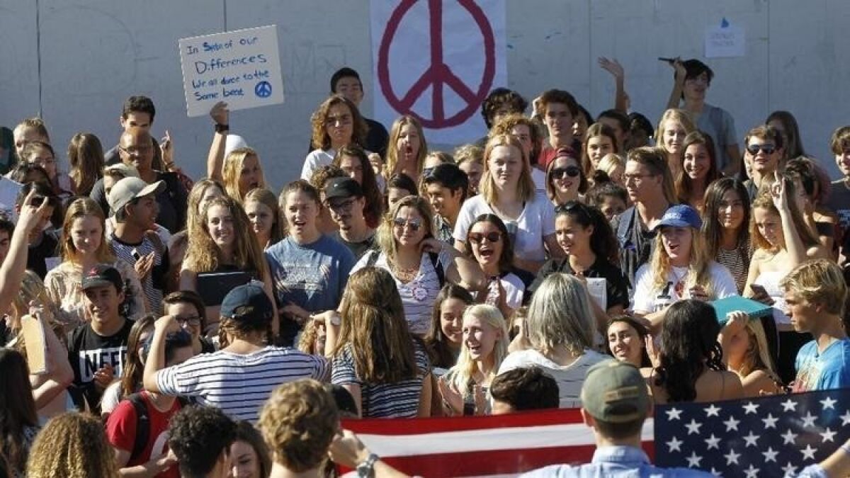 Students walked out of class on Nov. 10 to peacefully protest the outcome of the presidential election, gathering at an amphitheater at San Dieguito Academy. Other students who support Trump hold an American flag.