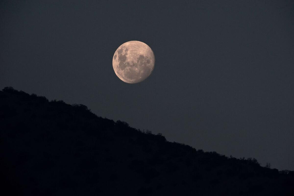 New research suggests the moon is 60 million years older than previously thought. Pictured here, the moon rising in Santiago, Chile.