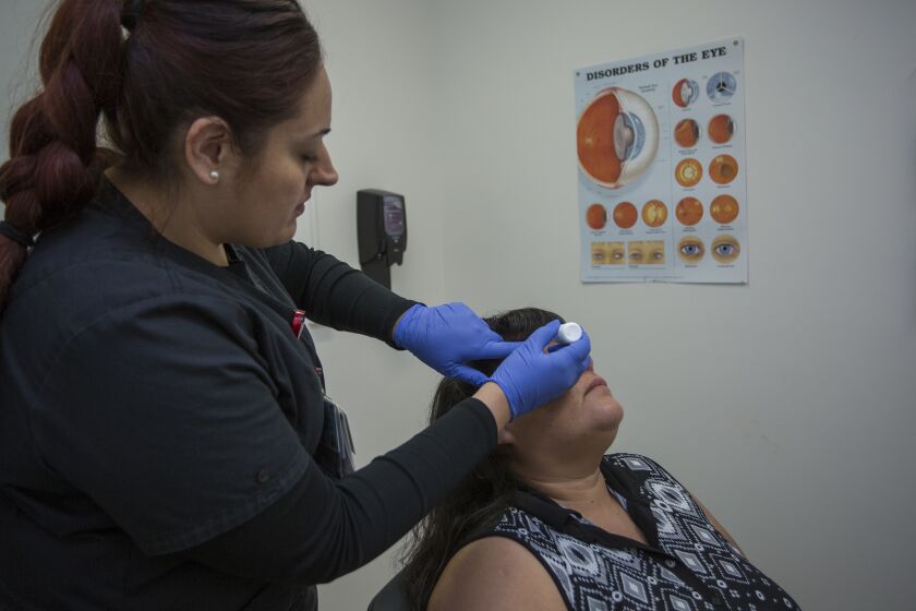 LOS ANGELES-CA-MAY 15, 2017: Retinal photographer Silvia Fletes applies drops to dilate the eyes of Rosa Guzman before photographing her retinas during diabetic retinopathy teleretinal screening by the Los Angeles County Department of Health Services in Los Angeles, California, May 15, 2017. LA County implemented a program to improve screening for blindness among diabetics. Primary care doctors take photos of patients' retinas and then send them to optometrists. A recent paper found that the technique cut wait times for eye screenings by 90 percent. (David McNew / For The Times)