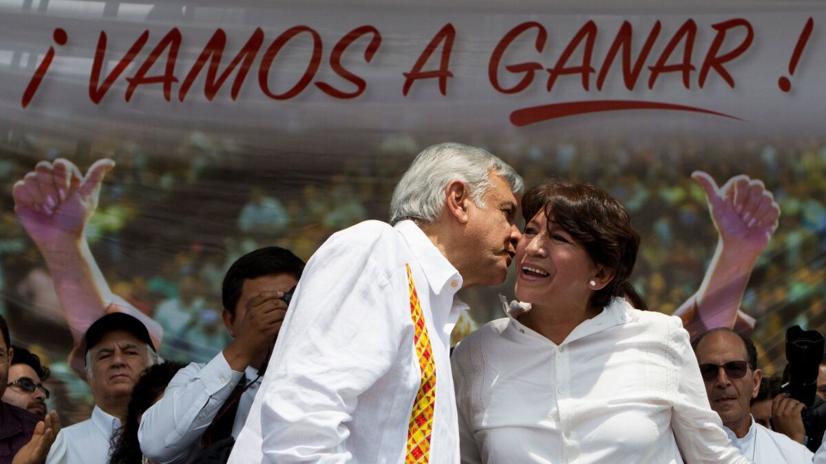 Andres Manuel Lopez Obrador, left, campaigns with Delfina Gomez in Nezahualcoyotl, Mexico state, under a banner reading in Spanish, "We are going to win," on May 28, 2017. She is running for Mexico state governor with his National Regeneration Movement, or Morena.