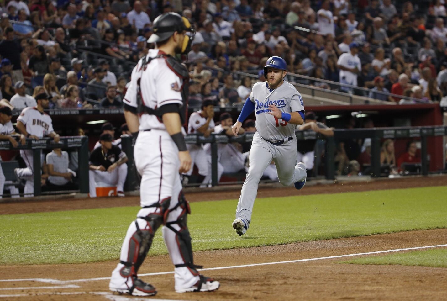 Los Angeles Dodgers' Max Muncy, right, heads home to score as Arizona Diamondbacks catcher Jeff Mathis, left, waits for a possible throw during the first inning of a baseball game Wednesday, Sept. 26, 2018, in Phoenix. (AP Photo/Ross D. Franklin)