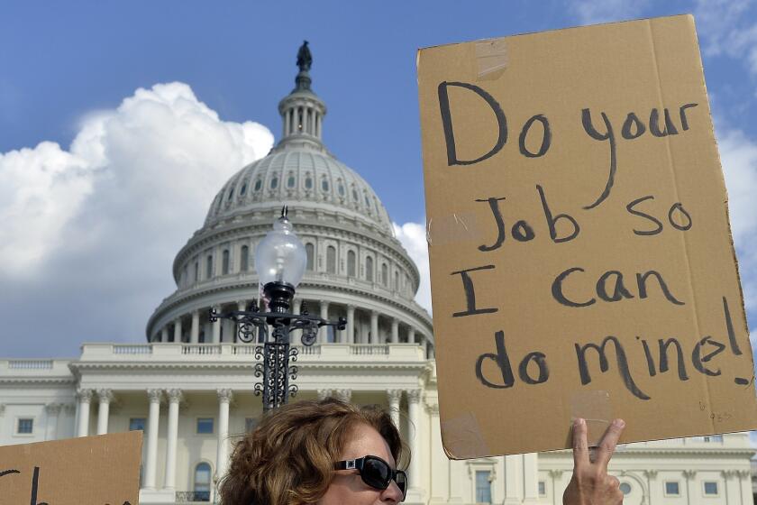 A protester holds up a sign outside the U.S. Capitol. Credit rating firm Moody's said that the government shutdown and debt ceiling crisis would not affect the country's credit rating.