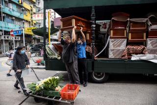 Empty coffins are delivered to a funeral services shop and funeral parlours in the Kowloon district of Hong Kong