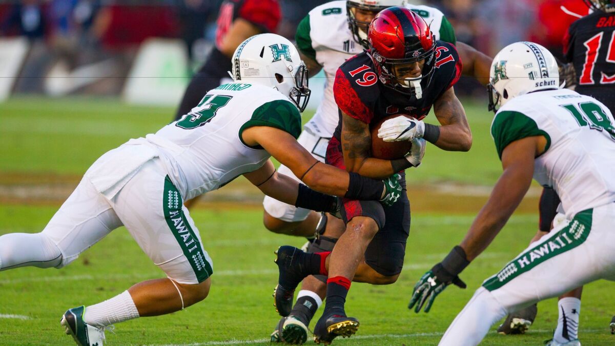 San Diego State running back D.J. Pumphrey rushes up the middle in a game against Hawaii. Opponents of a California bill to allow college athletes to profit from endorsements say the plan would have a negative impact on student-athlete programs.