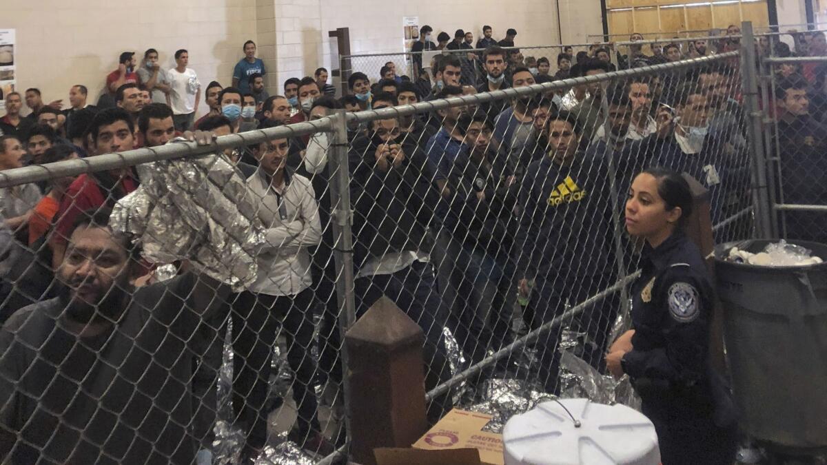 Hombres en un centro de detención de Inmigración y Control de Aduanas de Estados Unidos en McAllen, Texas, el 12 de julio de 2019, mientras el vicepresidente Mike Pence visita el lugar.
