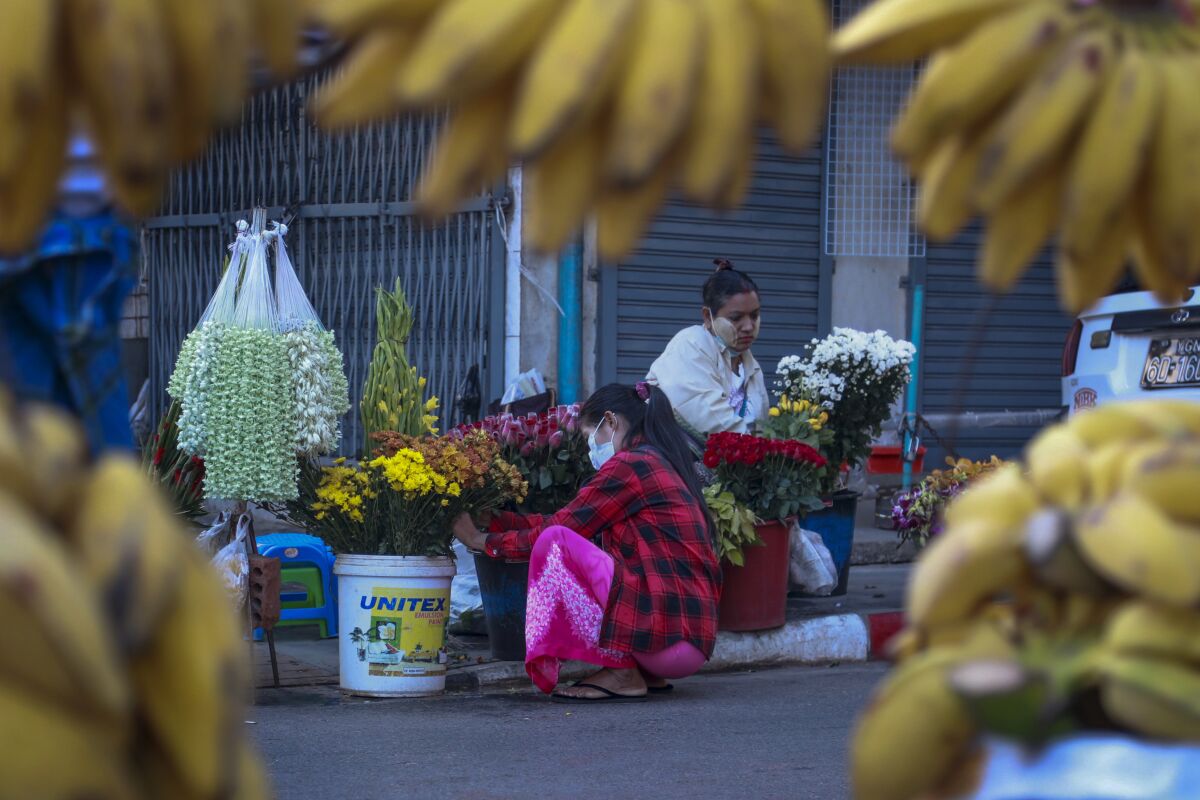 FILE - Woman arrange flowers at a street market in Yangon, Myanmar, on Feb. 2, 2021. World Bank economists say Myanmar's economy grew 3% in 2022 and will likely achieve the same pace of growth in 2023, but still lags far behind where it stood before the army seized power in early 2021. (AP Photo/Thein Zaw, File)