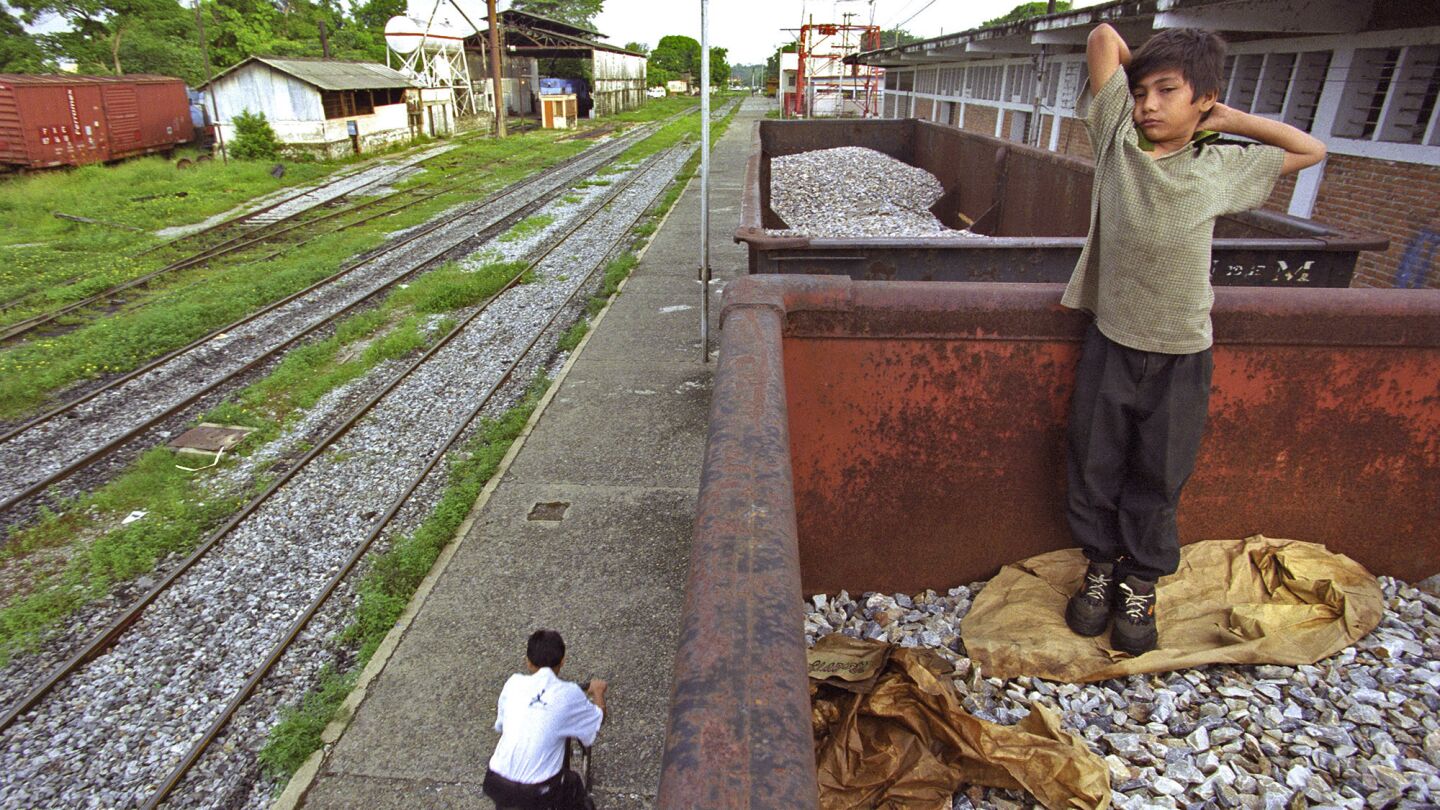 Denis stretches after a night spent in a freight car parked in Tapachula. The then-12-year-old had run away from home in San Pedro Sula, Honduras, with little more than his mother's San Diego phone number and a determination to find her.