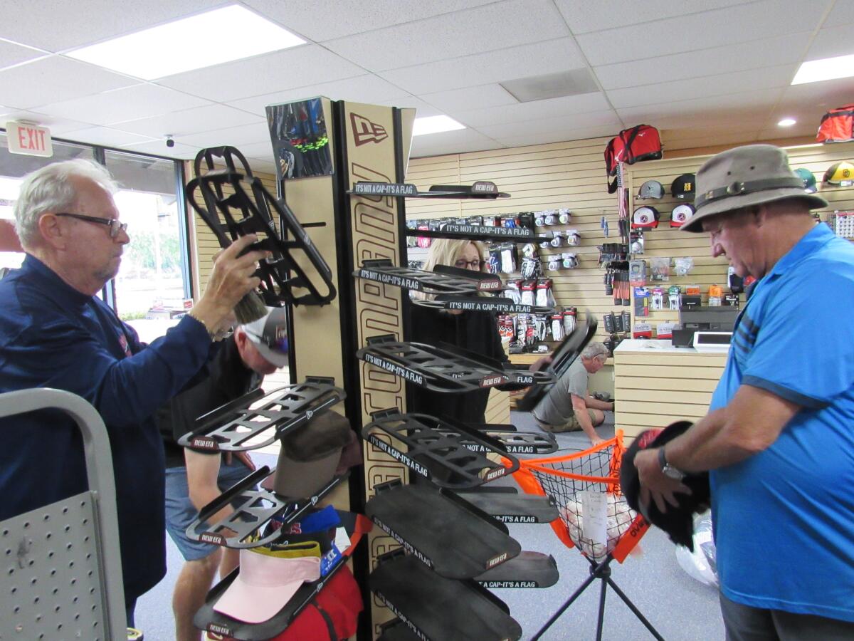 Berry's Athletic Supply owner John Enright (left) fixes some merchandise racks with friend Gibbie Scruggs.