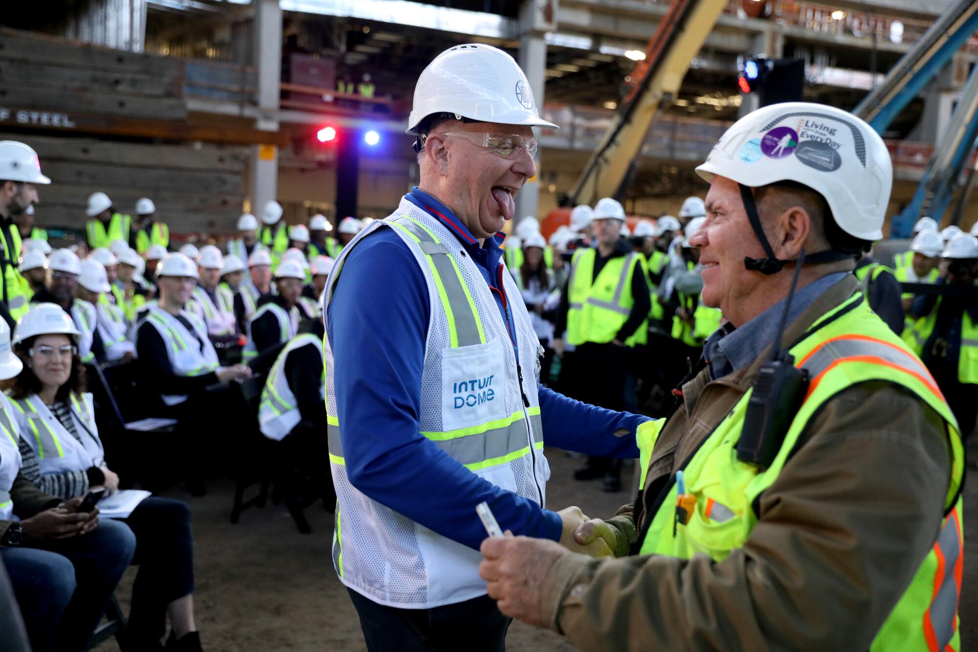 Clippers owner Steve Ballmer, left, shakes hands with a construction worker at the Intuit Dome.