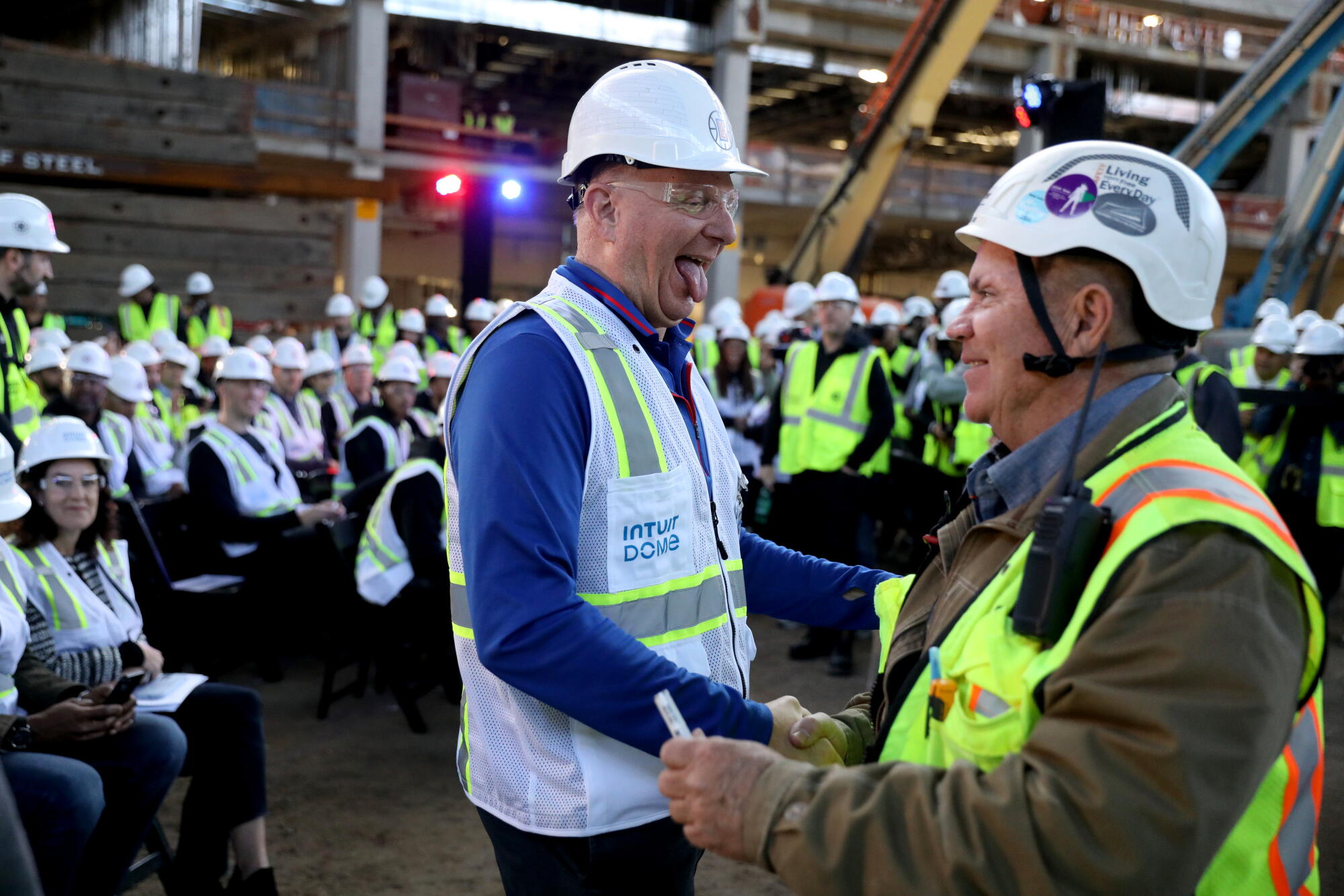 Clippers'ın sahibi Steve Ballmer (solda), Intuit Dome'da bir inşaat işçisiyle el sıkışıyor.